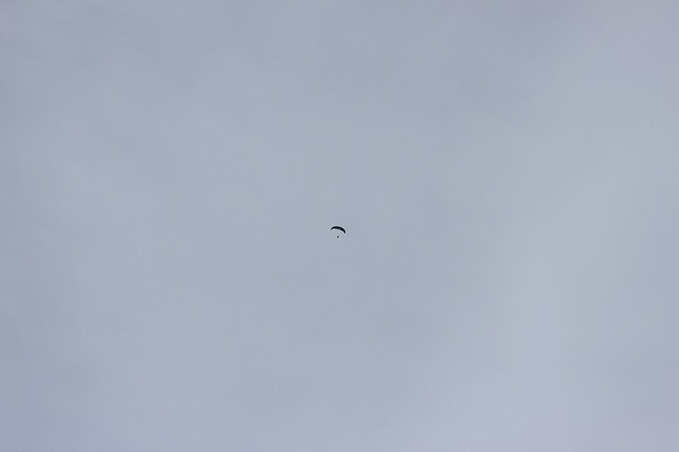 Gleitschirm im Flug über einem Alpental